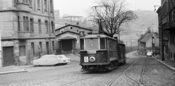 Až na tehdejší konec tramvajové tratě v Radlické ulici, přes romantickou jednokolejnou část, vystoupala souprava motorového vozu #2203 a vlečného vozu #1424 vypravená n linku 6. Dobový kolorit pražské periférie doplňují tři zaparkované automobily značky Trabant před domem č.or.138, který v Radlické ulici stojí dodnes. V pravé části snímku je patrná sjezdová výhybka ze smyčky Radlice. | 28.12.1973