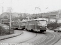 Souprava vozů T3.1 ev.č.6018+T3 ev.č.6527 vypravená na linku 16 vjíždí na splítkový úsek tramvajové tratě mezi Zlíchovem a Lihovarem, jenž byl umístěn na mostě přes železniční trať. | 22.2.1987