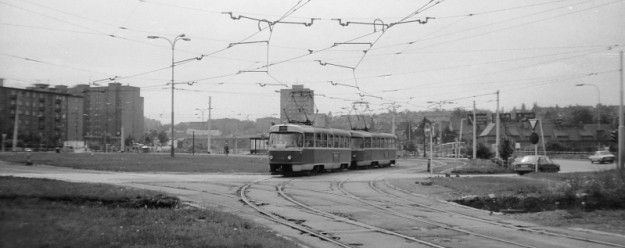 Souprava vozů T3 ev.č.6404+6405 vypravená na linku 11 opouští vnitřní koleji původní smyčky Spořilov, která jak je ze snímku patrné, byla umístěna ve středu kruhového objezdu. Smyčce zbývá již jen šest týdnů provozu... | 15.5.1986