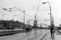 Na snímku projíždí souprava vozů T3 vedená vozem #6628 na lince 7 obloukem z ulice Jana želivského k Olšanským hřbitovům. V pozadí míří do finále výstavba prodloužení trasy metra A. | 1979