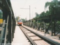 Splítkovým úsekem na mostní konstrukci nad stavbou metra IV.C1 projíždí k zastávce Trojská souprava vozů T3 #6866+6867 vypravená na linku 5. | 7.7.2001