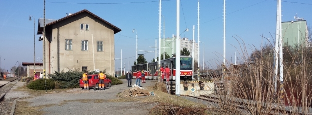 Vůz KT8D5.RN2P ev.č.9091 vyčkává na předávací koleji na přisunutí vozu Škoda 14T ev.č.9127 na plošinových vozech k předávací rampě. | 10.3.2015