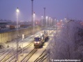 Lokomotiva 740.469-2 a na třech plošinových vozech ložený vůz Škoda 14T ev.č.9115 na nádraží Praha-Zličín vyčkávají za mrazivého rána na povolení posunu k rampě předávací koleje | 28.12.2006