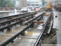 Zřizování tramvajové tratě systémem W-tram u zastávky Jiráskovo náměstí, kolejnice jsou podloženy betonovými kostkami, které při výstavbě tratí tímto systémem jednotka Dopravní cesta Tramvaje nepoužívá. Na kolejích již leží předmontovaná kolejové pole, tedy kolejnice spojené rozchodnicemi. které zde zůstávají i po zabetonování. Vrchní stavba Dopravního podniku Praha toto nevyužívá. | 2.6.2010